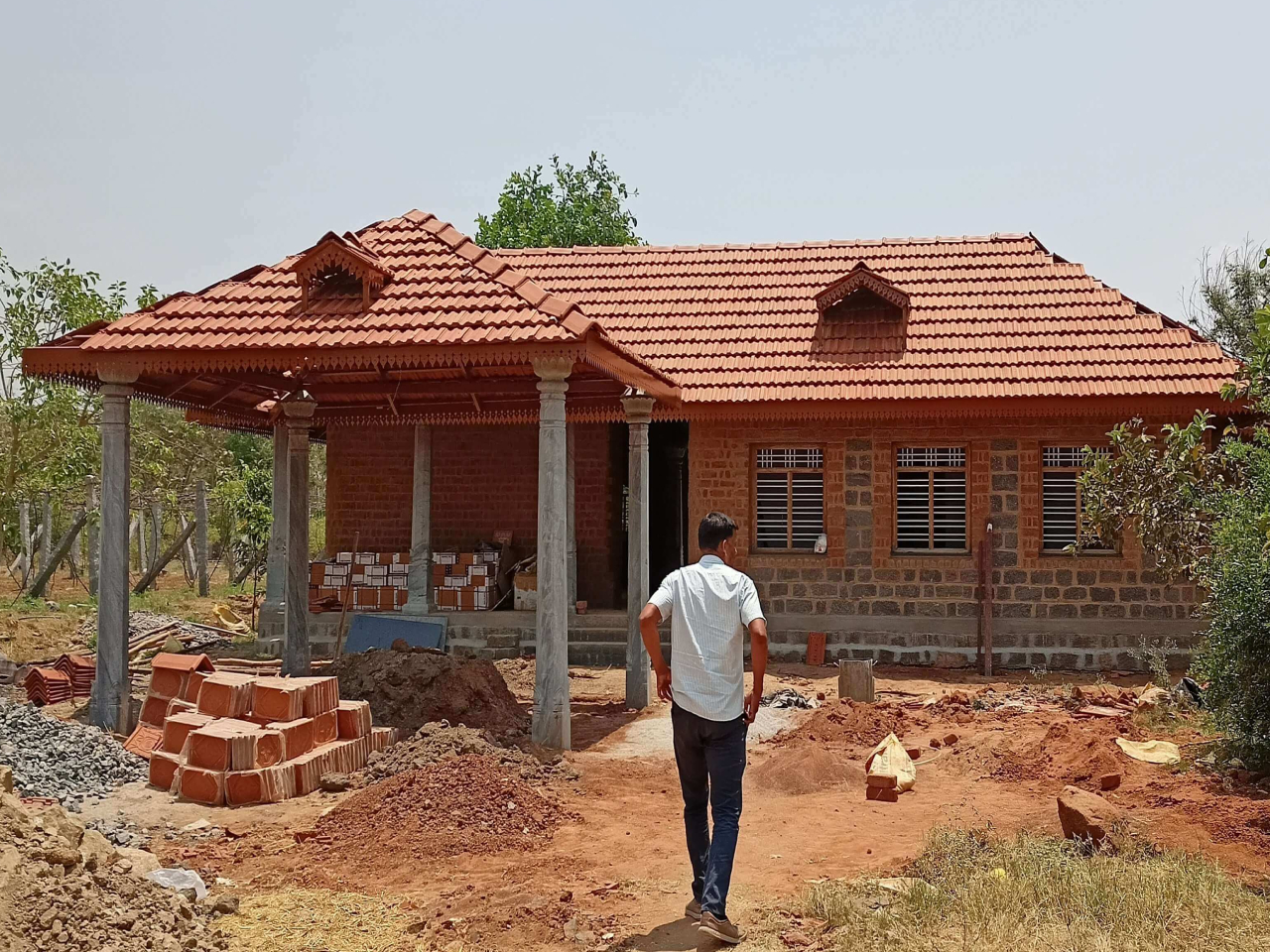 Dr. Senthil’s Farm house, Dharmapuri - A load bearing structure with stone, cob and brick composite walls, tiled roof over MS channels  and central courtyard. Wooden doors and windows, Stone pillars and first floor deck. Area 1600 sq ft ; Total cost 19,00,000/-